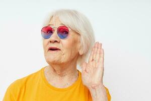 sorridente anziano donna contento stile di vita nel giallo magliette leggero sfondo foto