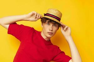 ritratto di un' giovane Riccio uomo nel un' rosso maglietta con un' moda cappello stile di vita inalterato foto