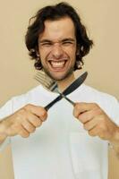 uomo nel un' bianca maglietta con coltello con forchetta stile di vita inalterato foto