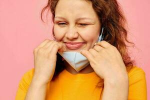 bellissimo donna nel un' giallo maglietta medico maschera protezione ritagliata Visualizza inalterato foto