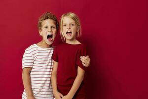 carino elegante bambini sorridente e in posa nel casuale Abiti contro isolato sfondo foto