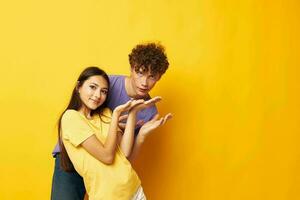 carino giovane coppia nel colorato magliette in posa amicizia divertimento isolato sfondo inalterato foto