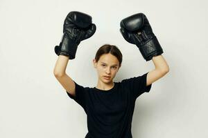 bellissimo ragazza nel boxe guanti nel nero pantaloni e un' maglietta stile di vita inalterato foto