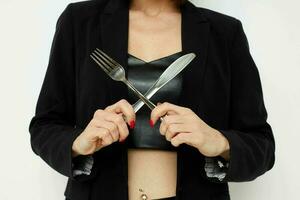 attraente donna coltello e forchetta nel mani emozioni in posa isolato sfondo foto