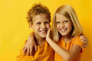 carino prescolastico bambini nel giallo magliette in piedi lato di lato infanzia emozioni giallo sfondo foto