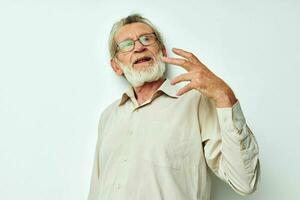 ritratto di contento anziano uomo con un' grigio barba nel un' camicia e bicchieri inalterato foto
