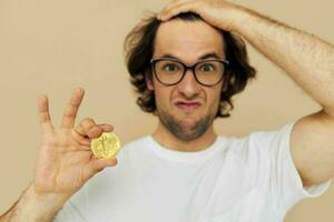 attraente uomo con bicchieri oro bitcoin nel mani stile di vita inalterato foto