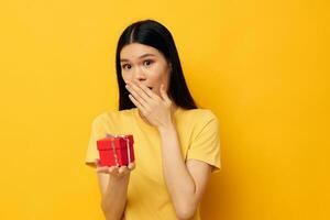 donna con asiatico aspetto poco rosso regalo scatola divertimento giallo sfondo inalterato foto