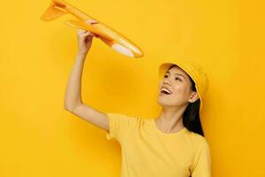donna con asiatico aspetto con un' giallo aereo nel il suo mani un' giocattolo isolato sfondo inalterato foto