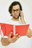 bello uomo parlando su il Telefono rosso bloc notes isolato sfondo foto