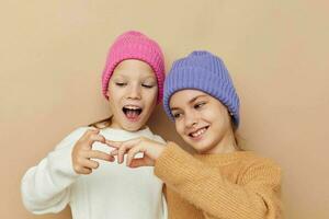 Due divertente ragazze abbracciare in posa colorato cappelli foto