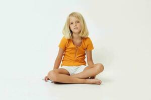 bella ragazza con biondo capelli seduta su il pavimento isolato leggero sfondo emozioni foto