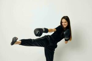 giovane bellissimo donna nel nero gli sport uniforme boxe guanti in posa isolato sfondo foto