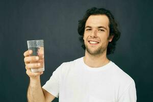 allegro uomo bicchiere di acqua nel il suo mani emozioni in posa beige sfondo foto