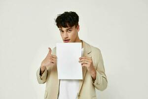 ritratto di un' giovane uomo in posa con un' bianca foglio di carta isolato sfondo inalterato foto