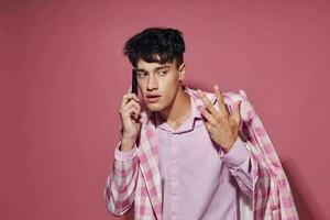 bella uomo con un' Telefono nel mano rosa blazer moda elegante stile isolato sfondo inalterato foto