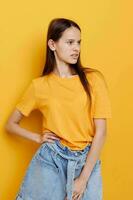 giovane bellissimo donna moda nel giallo maglietta denim pantaloncini isolato sfondo foto