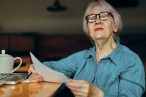 anziano donna documenti opera foglio di carta e penna libero professionista lavori inalterato foto