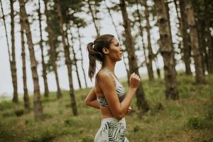 giovane donna fitness in esecuzione al sentiero nel bosco foto