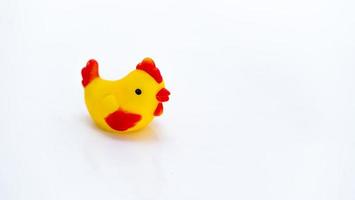 primo piano di un piccolo pollo giocattolo seduto su sfondo bianco isolato foto