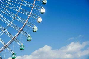 avvicinamento e Ritaglia gigante Ferris ruota su luminosa blu cielo sfondo con spazio per testi. foto
