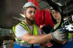 tutti e due di ingegneri installazione e analisi un' grande robotica braccio. prima invio esso per i clienti per uso nel il industria foto