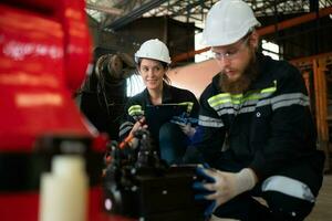 tutti e due di ingegneri installazione un' piccolo robotica braccio è essere installato per test. prima invio per i clienti per industriale uso. foto