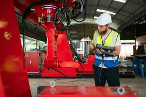 un ingegneri installazione e analisi un' grande robotica braccio. prima invio esso per i clienti per uso nel il industria foto