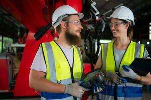 tutti e due di ingegneri installazione e analisi un' grande robotica braccio. prima invio esso per i clienti per uso nel il industria foto