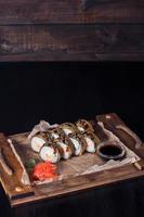 involtini di frutti di mare su un vassoio di legno, bella porzione, sfondo scuro foto
