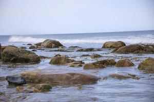 onde che si infrangono sulle rocce dell'oceano in estate foto