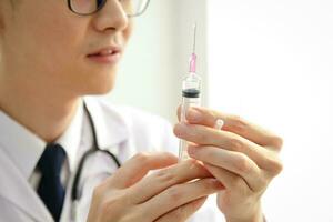 asiatico maschio medico Tenere un' siringa per iniezione per trattare malattia per pazienti. concetto di medico Servizi nel ospedali. profilattico vaccino foto