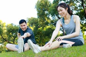 asiatico maschio e femmina coppia esercizio nel il all'aperto parco nel il mattina. essi siamo sano, sorridente e contento. fitness concetto, Salute cura foto