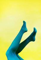 pezzo pop art di gambe di giovane donna in calzamaglia su uno sfondo giallo yellow