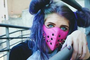 giovane donna punk che indossa una maschera rosa foto