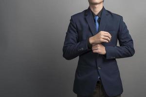primo piano di uomo d'affari in abito blu fiducioso su sfondo grigio foto