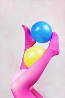 pop art sulle gambe che indossano collant rosa e tengono in mano palloncini