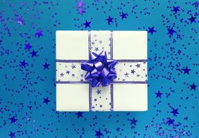 confezione regalo e stelle su sfondo blu. posa piatta monocromatica. foto
