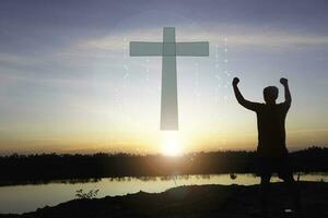 un' uomo solleva sua mani e attraversare con tramonto.lei è così calma speranza, rispetto, spirituale , crocifisso, religione e pace.foto cristiano e speranza concetto idea. foto