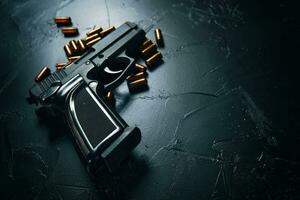 pistola con cartucce sul tavolo di cemento scuro. foto