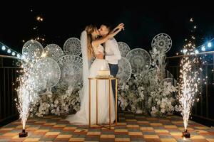 Novelli sposi felicemente tagliare e gusto il nozze torta foto