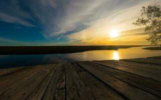 bellissimo tramonto con molo e fiume foto