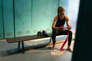 donne se stesso difesa ragazza potenza. donna combattente preparazione per combattimento involucro mani con rosso boxe impacchi gli sport protettivo bende. forte ragazza pronto per combattimento attivo esercizio sparring allenarsi addestramento. foto