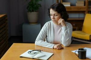 triste stanco malato malato solitario deluso più vecchio anziano donna seduta a casa solo. infelice maturo nonna sperimentare dolore parente Morte cattivo notizia. stressato Sambuco signora sofferenza a partire dal solitudine. foto