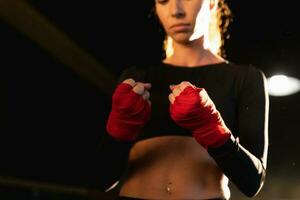 donne se stesso difesa ragazza potenza. donna combattente preparazione per combattimento involucro mani con rosso boxe impacchi gli sport protettivo bende, forte mani pronto per combattimento attivo esercizio sparring allenarsi formazione foto