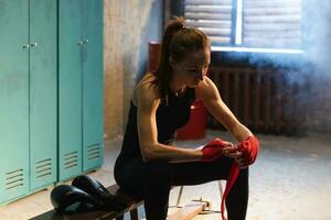 donne se stesso difesa ragazza potenza. donna combattente preparazione per combattimento involucro mani con rosso boxe impacchi gli sport protettivo bende. forte ragazza pronto per combattimento attivo esercizio sparring allenarsi addestramento. foto