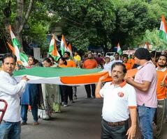 delhi, India -15 giugno 2023 - grande gruppo di persone durante grande tiranga yatra organizzato come parte di il azadi ka amrit mahotsav per celebrare il 76 anniversario di dell'india indipendenza, indiano bandiera marzo foto