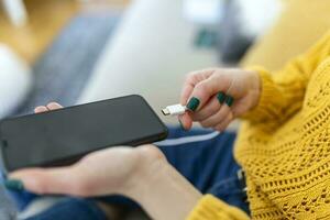 donna mani tamponamento un' caricabatterie nel un' inteligente Telefono. donna utilizzando smartphone con accumulatore di energia, ricarica energia per inteligente Telefono. donna ricarica batteria su mobile Telefono a casa foto