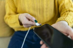 donna mani tamponamento un' caricabatterie nel un' inteligente Telefono. donna utilizzando smartphone con accumulatore di energia, ricarica energia per inteligente Telefono. donna ricarica batteria su mobile Telefono a casa foto