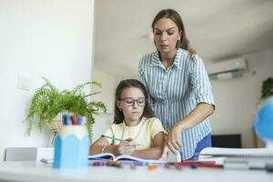 stressato madre e figlia frustrato al di sopra di fallimento compiti a casa, scuola i problemi concetto. triste poco ragazza trasformato lontano a partire dal madre, fa non volere per fare noioso compiti a casa foto